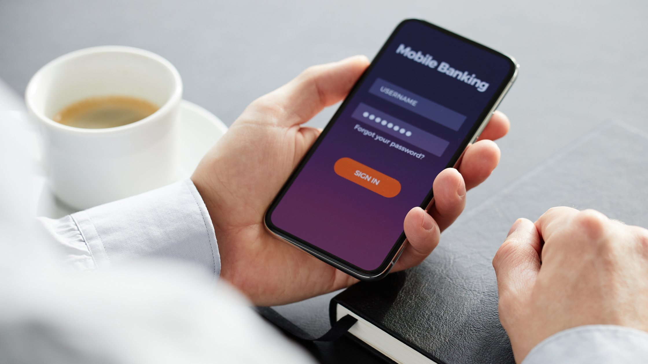 Hand holding a smartphone, logging into mobile banking