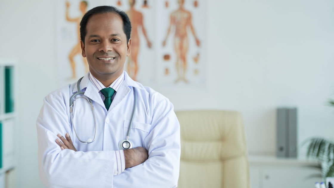 Smiling Doctor standing in his office